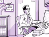 El médico de Nia, en su consultorio, trabajando en la computadora.